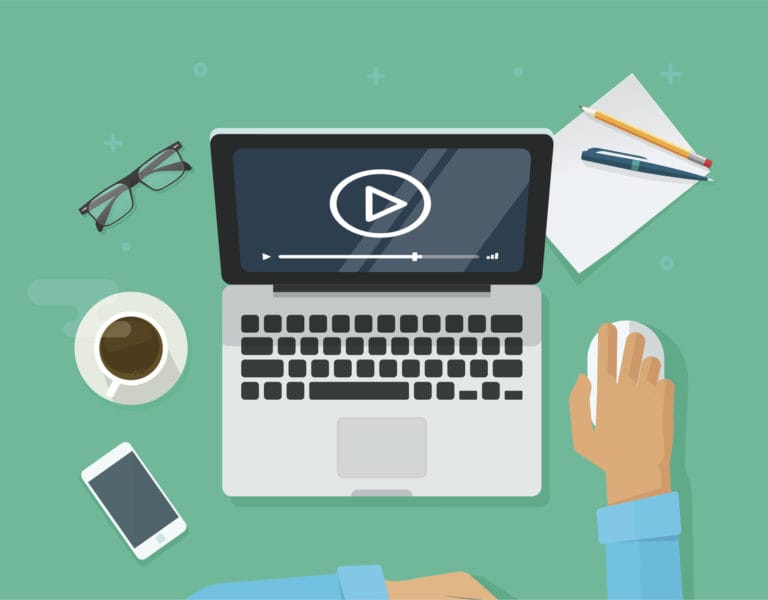 workplace with person watching a video on laptop