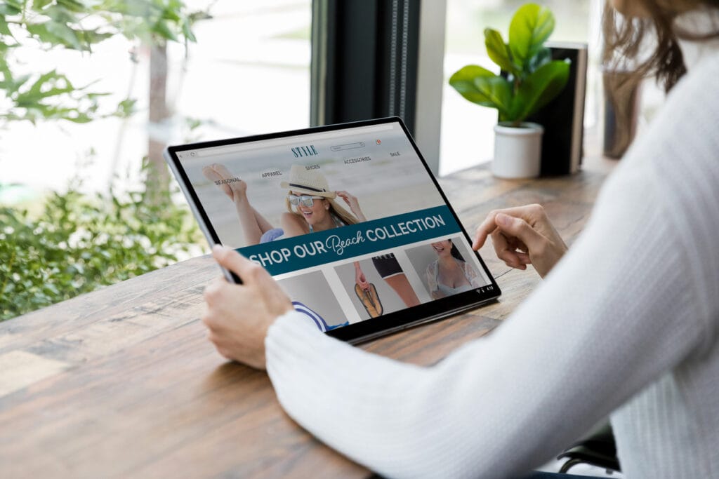 An unrecognizable woman searches an eCommerce website on a digital tablet