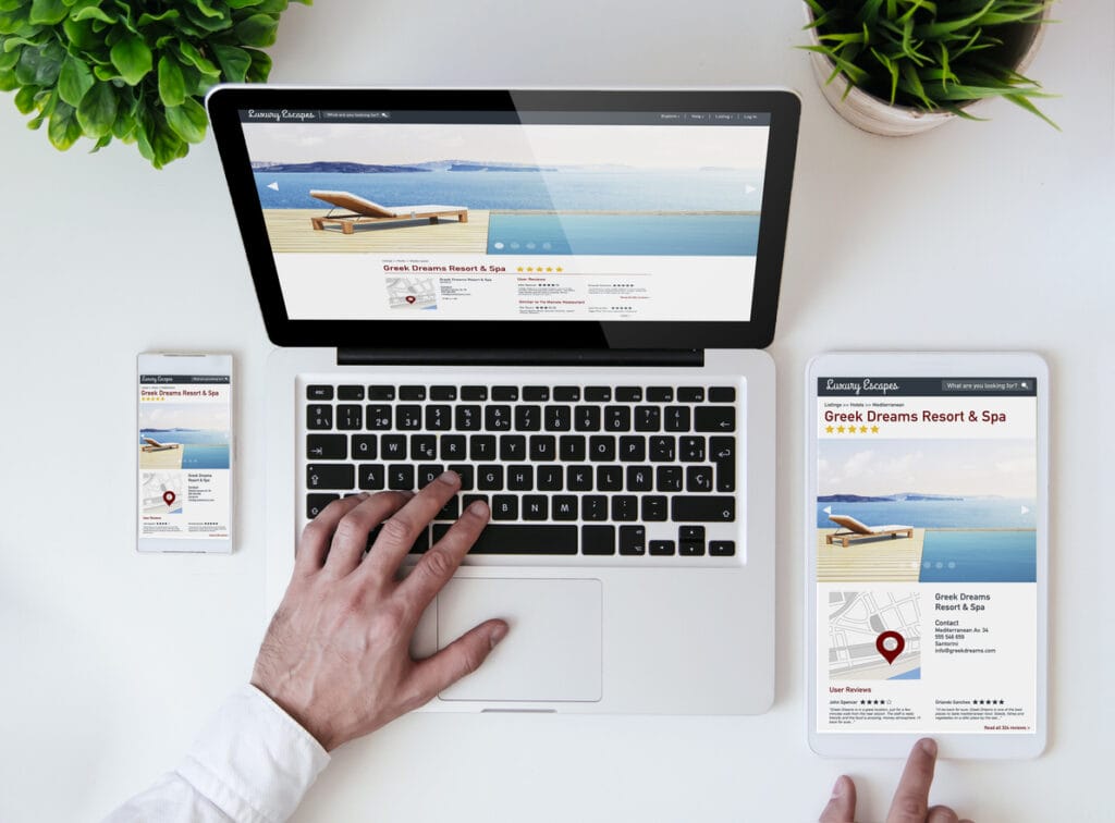 Feature deployment on responsive website design shown on office tabletop with tablet, smartphone and laptop