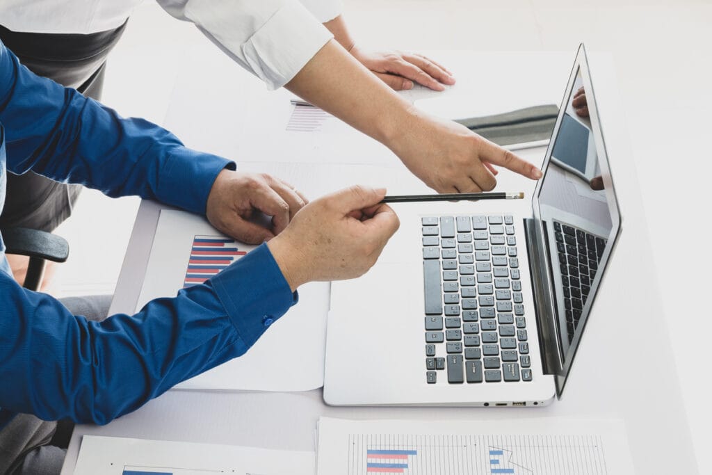 An enterprise web development team working together on a laptop