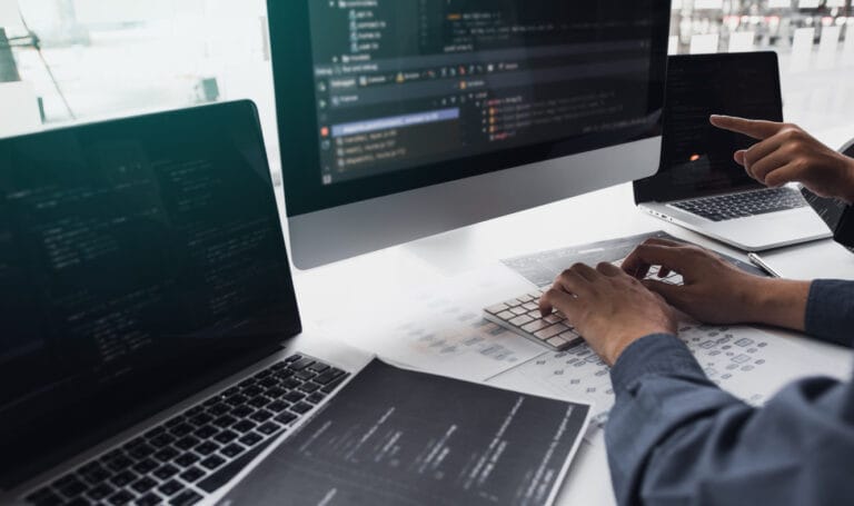 A cropped shot of two programmers working on laptops with Agile for website development
