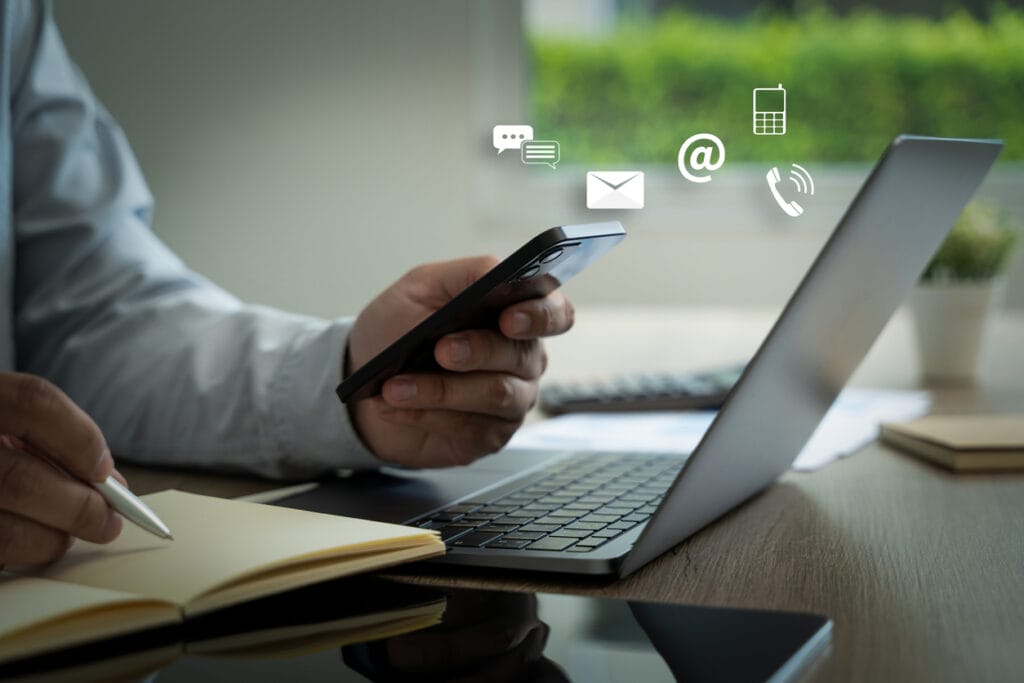 A cropped shot of a male holding a mobile phone with icons overlay to show online collaboration with the team for WordPress projects