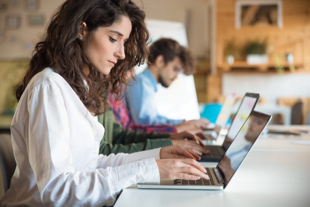 An enterprise media team working on their individual laptops in a modern office