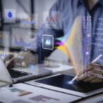 Data scientist uses a computer and tablet for analysis of enterprise media information using AI