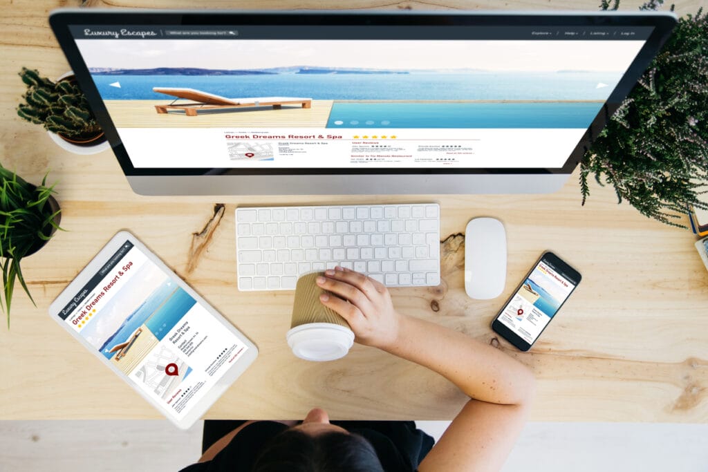 AI + WordPress: Overhead view of a woman drinking coffee and browsing a luxury escapes website on different devices