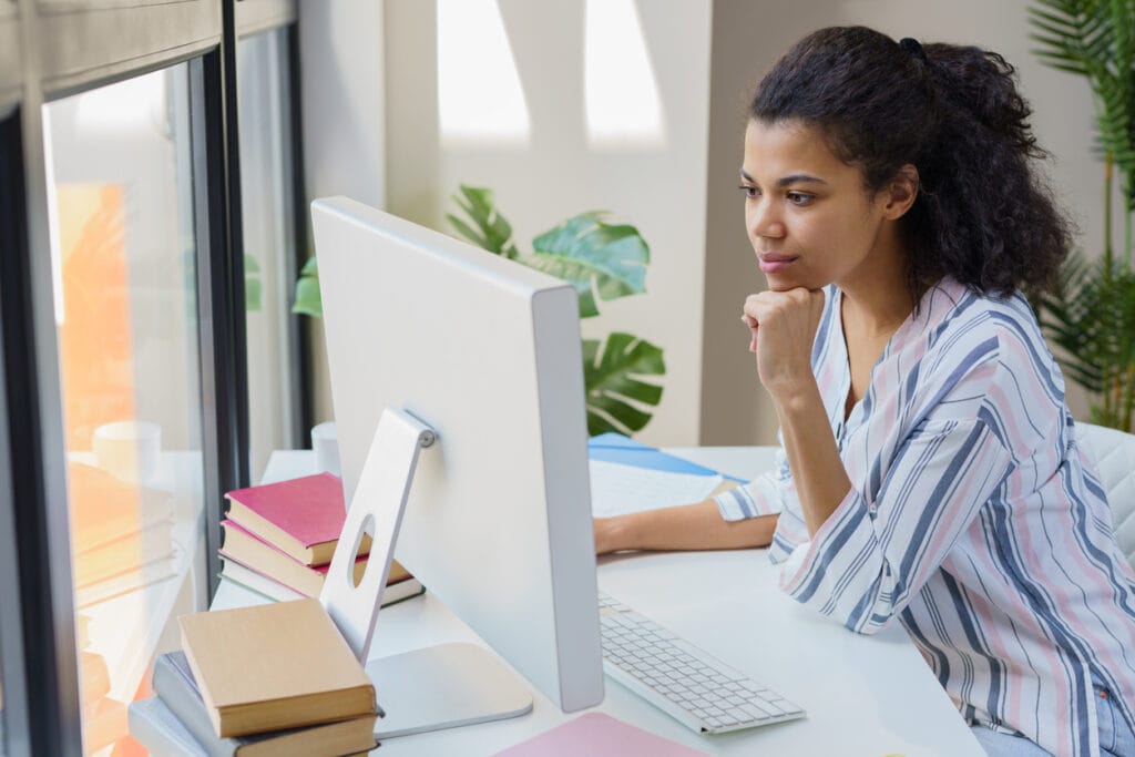 Health and wellness content: Pensive lady looking at her computer monitor in the office