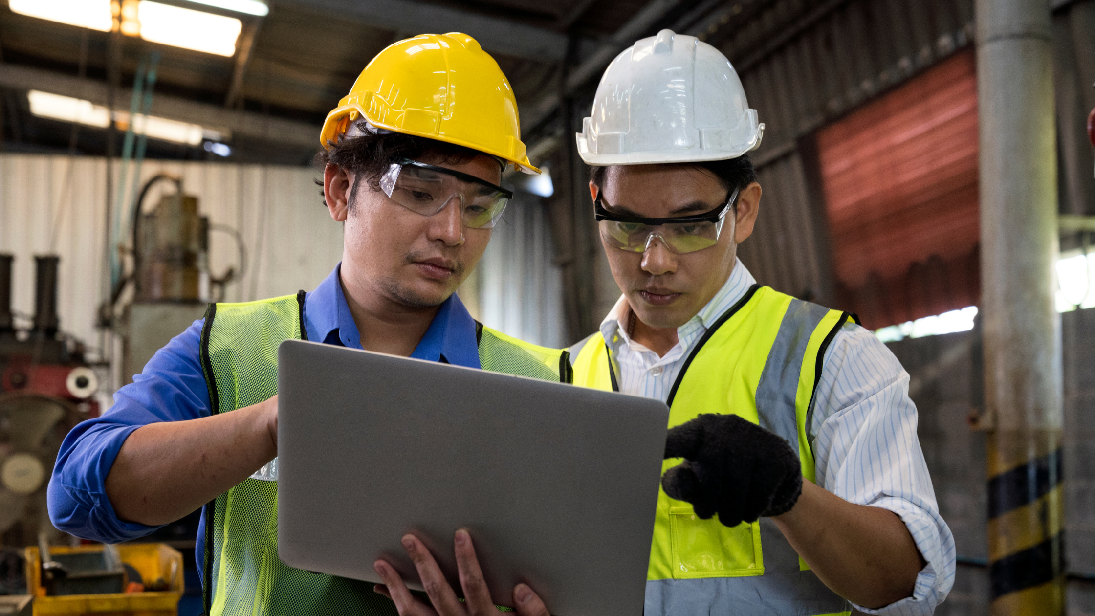Two manufacturing company workers reviewing a tablet